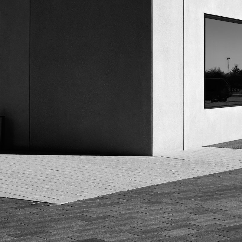 gebaeude-mit-fenster-licht-und-schatten-in-schwarz-weiß-links
