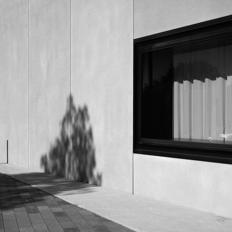 gebaeude-mit-fenster-licht-und-schatten-in-schwarz-weiß-mitte
