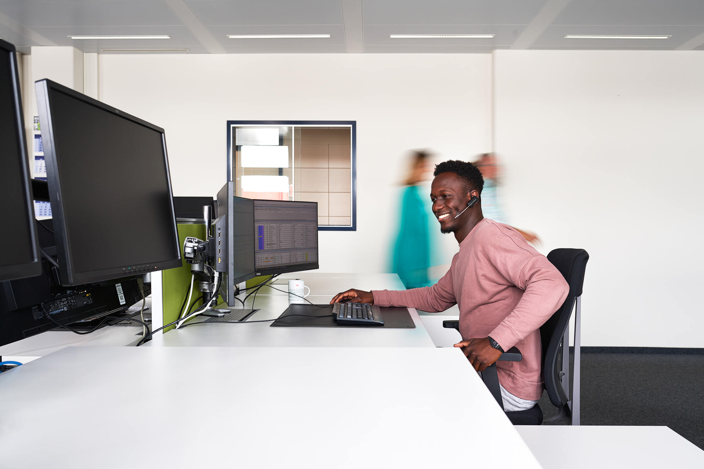 business-portrait-von afrodeutschem-disponent-der-am-computer-sitzt