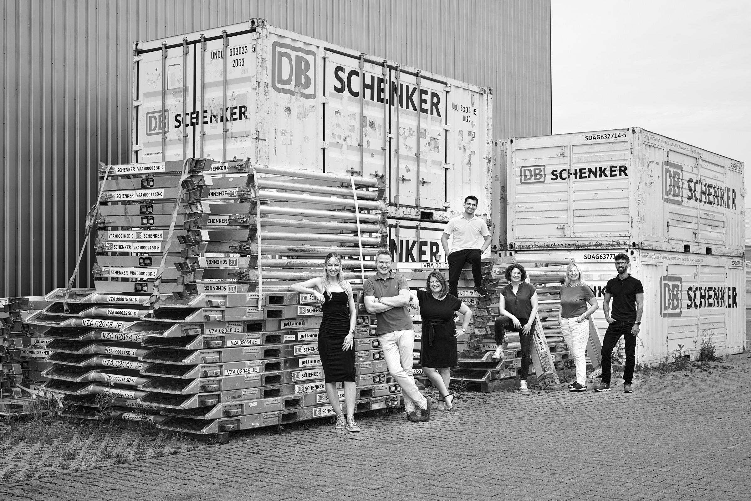 gruppenbild-team-gebietsleitung-luftfracht-vor-containern
